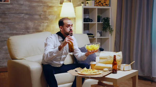 Empreendedor cansado e animado com gravata comer batatas fritas — Fotografia de Stock