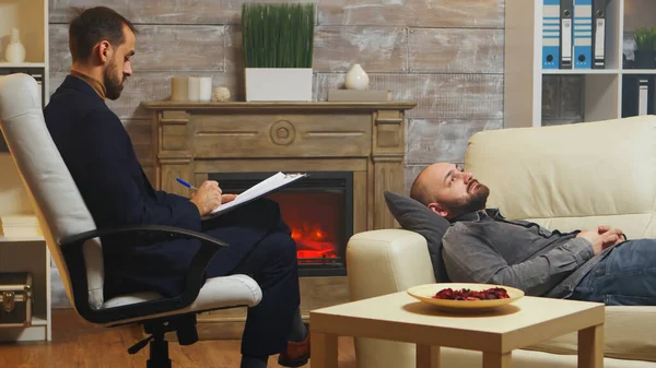 Бородатый мужчина лежит на диване на семейной терапии — стоковое фото