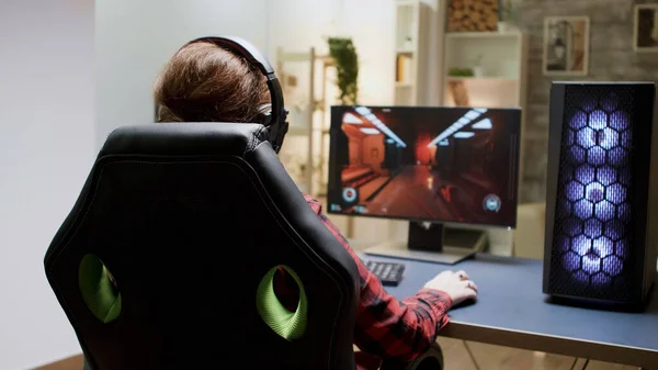 Achteraanzicht van de vrouw met rood haar spelen online shooter games — Stockfoto