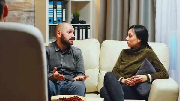 Young man telling his wife in front of therapist Royalty Free Stock Images