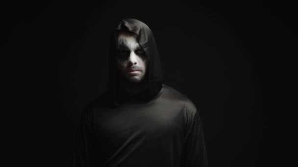 Junger Mann verkleidet sich wie ein Sensenmann vor schwarzem Hintergrund — Stockvideo