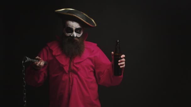Человек, одетый как пьяный пират на черном фоне — стоковое видео