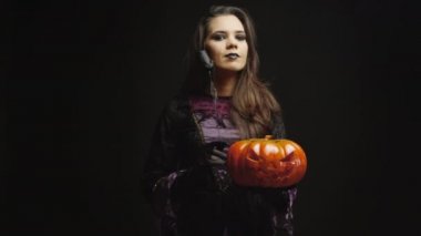 Cadı gibi giyinmiş genç bir kadın.