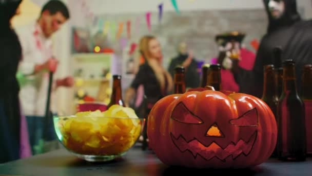 Zucca spaventosa sulla festa mentre un gruppo di persone balla festeggiando Halloween . — Video Stock