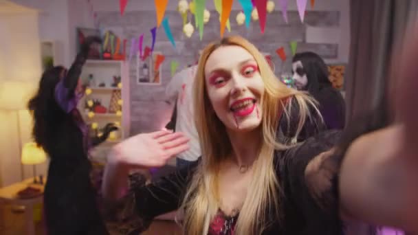 Поп молодой женщины нарядился в чародейку, приглашая друзей на Хэллоуин — стоковое видео