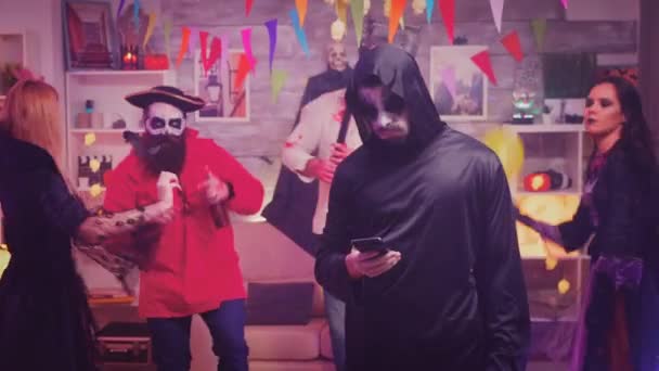 Bored young man dressed up like grim reaper — Stock Video
