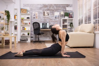 Kafkasyalı genç bir kadın yoga minderinde otururken dikkat çekmeye çalışıyor.