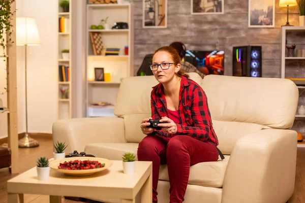 Mujer gamer jugando videojuegos en la consola de la sala de estar — Foto de Stock