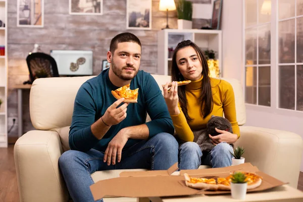 Lindo jovem casal comer pizza enquanto assistindo TV — Fotografia de Stock