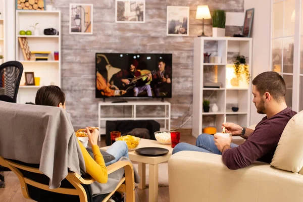 Вид на пару в гостиной, смотрящую фильм по телевизору — стоковое фото