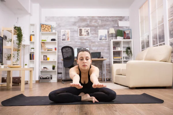 Jonge vrouw in sportschoenen zittend op lotus yoga pose — Stockfoto