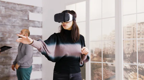 Vrouwelijke architect met behulp van virtual reality bril in leeg appartement — Stockfoto