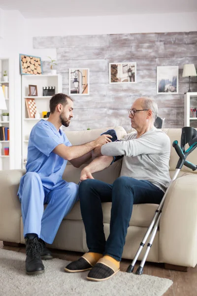 Jonge assistente in het verpleeghuis controleert de bloeddruk — Stockfoto