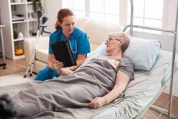 Γυναίκα γιατρός στο γηροκομείο χρησιμοποιώντας το tablet υπολογιστή — Φωτογραφία Αρχείου