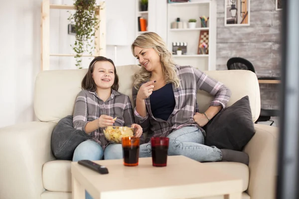 Bambina e sua madre ridono mentre guardano la tv — Foto Stock