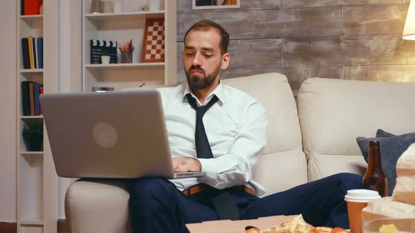 Fáradt üzletember a nappaliban dolgozik laptop — Stock Fotó
