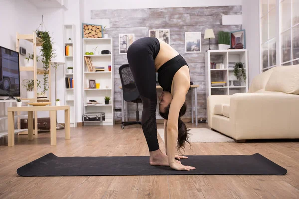 Donna caucasica che fa yoga flessibilità posa sul tappeto — Foto Stock