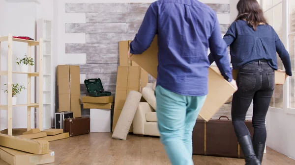 Молодая пара несет коробки в своей новой квартире — стоковое фото