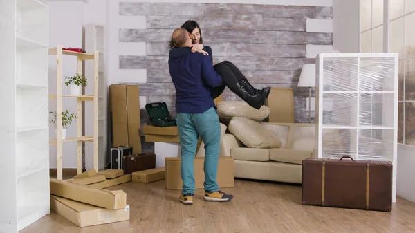 Heyecanlı erkek arkadaş yeni dairesinde kız arkadaşına omuz atıyor. — Stok fotoğraf