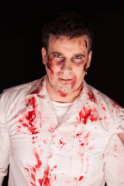 Siyah arka plandaki bir cinayetten sonra üzerinde kan olan bir zombi.