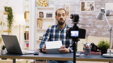 Yakışıklı sakallı vlog kaydedici bir eleştiri kaydediyor