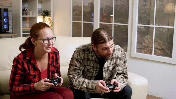 Пара хіпстерів сидить на дивані, граючи у відеоігри — стокове фото