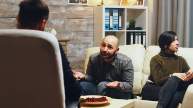 Angry boyfriend at couple therapy while girlfriend is crying