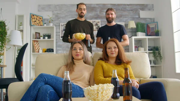 Ung kvinna anländer med pizza för att titta på en fotbollsmatch — Stockfoto