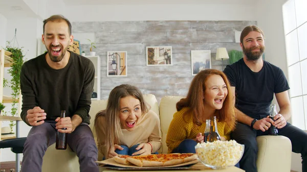 Grupp av vänner sitter på soffan med hjälp av sina smartphones — Stockfoto