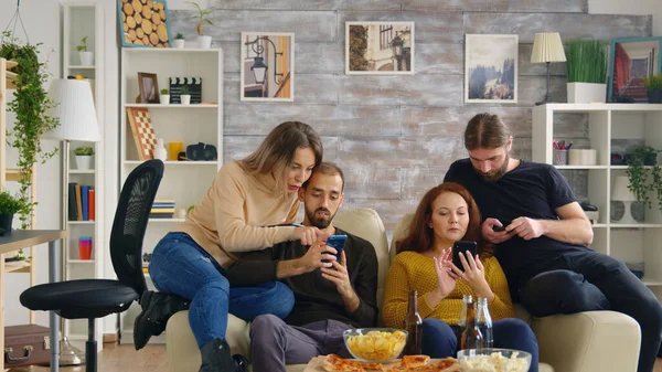 Přátelé na telefony v útulném světlém obývacím pokoji — Stock fotografie