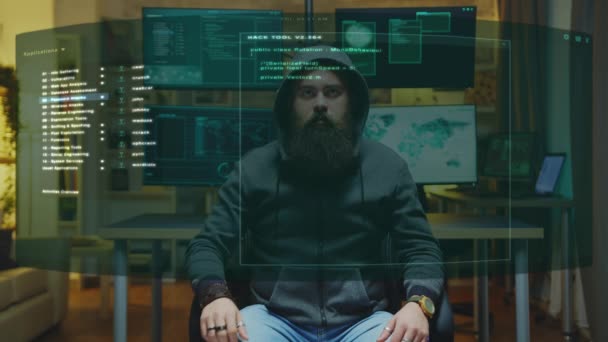 Бородатый хакер работает на дисплее виртуальных голограмм перед ним — стоковое видео