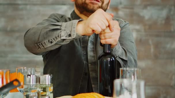 Közelkép egy férfiról, aki kinyitott egy üveg vörösbort. — Stock videók