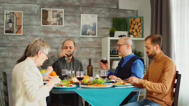 Junger bärtiger Mann trinkt mit seinem Vater ein Glas Wein — Stockvideo