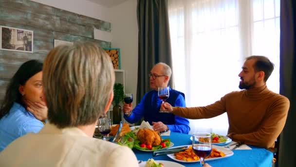 Красивая женщина улыбается во время ужина со своей семьей — стоковое видео