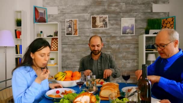 Zoom fuera de tiro de la familia disfrutando de deliciosa comida — Vídeos de Stock