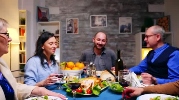 Přiblížit záběr rodinných cinkajících sklenic červeného vína — Stock video