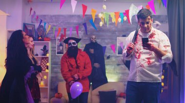 Telefonunu baltalı korkunç zombi kullanıyor.