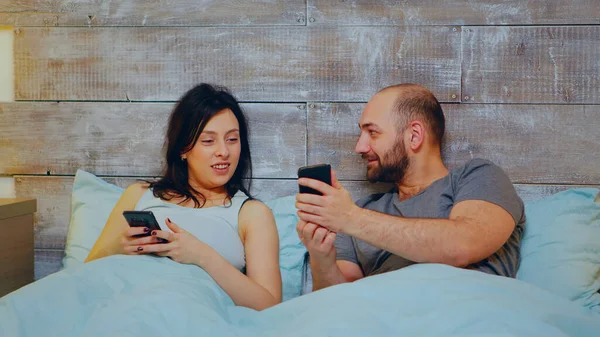 Jovem casal alegre usando smartphone — Fotografia de Stock
