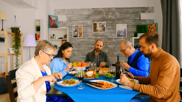 Zoom out shot of family enjoying delicious meal