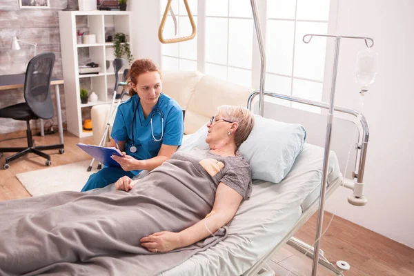 Oudere vrouw ligt in verpleeghuis bed — Stockfoto