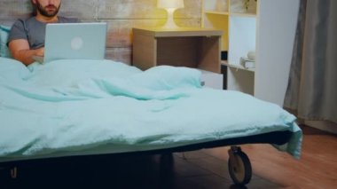 Genç adam geç saatlere kadar bilgisayar başında çalışıyor.