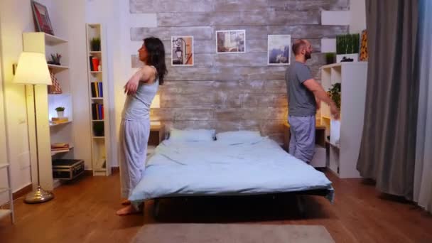 Young married couple falling back on bed after a crazy day at work — Stock Video