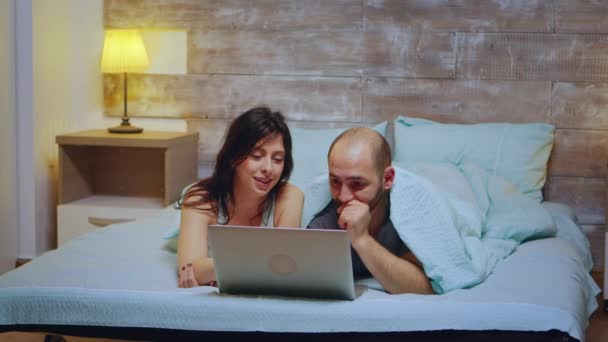 Couple wearing pajamas lying in bed — Stock Video