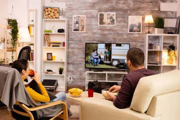 Zadní pohled na pár v obývacím pokoji sledování filmu na televizoru — Stock fotografie