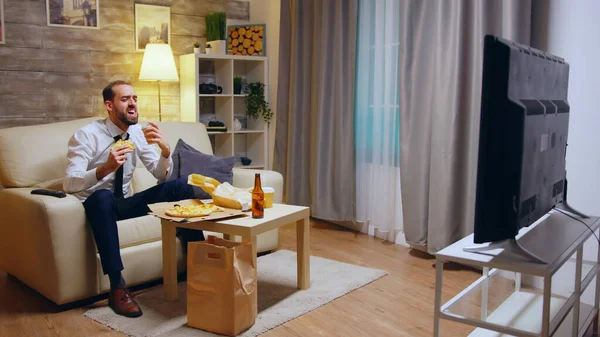 Hombre de negocios con corbata comiendo pizza y riendo — Foto de Stock