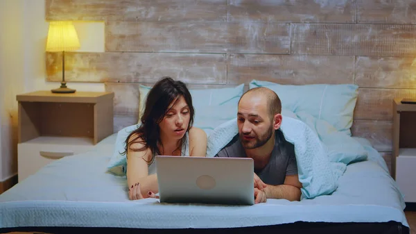 Casal vestindo pijama deitado na cama — Fotografia de Stock