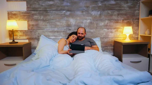 Zoom em tiro de jovem casal deitado na cama — Fotografia de Stock