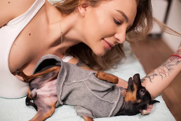 쾌활 한 여자와 애완 동물 이 침대에서 노는 모습 — 스톡 사진