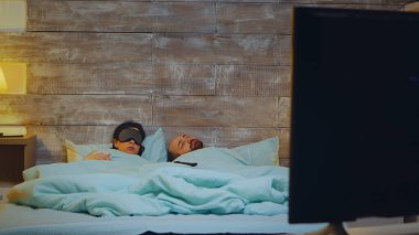 Genç adam pijamalarıyla televizyon izlerken uyuyakalıyor.