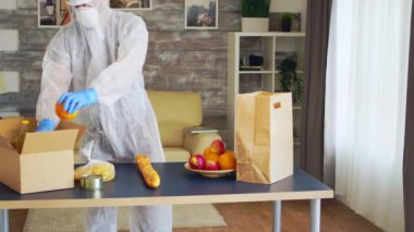 Koruyucu giysili gönüllü yiyecek paketliyor.